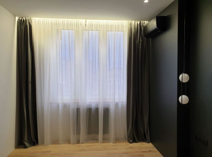 Темно-серые бархатные шторы и белый тюль в интерьере спальни